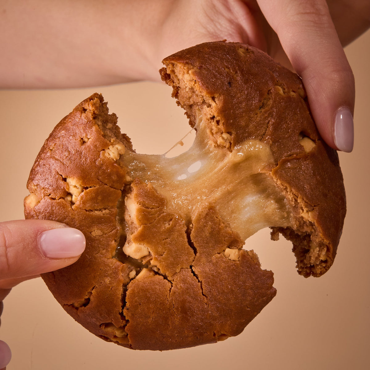 Hands holding Protein Cake Caramel Cream, showing the inside