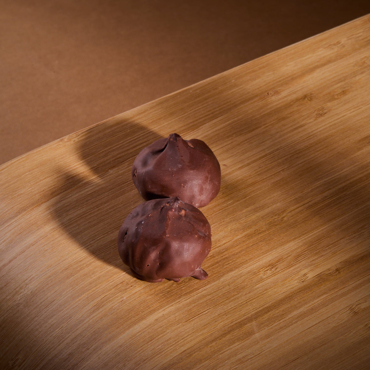 Cocoa Coated Protein Balls Hazelnut Cream on a wooden board