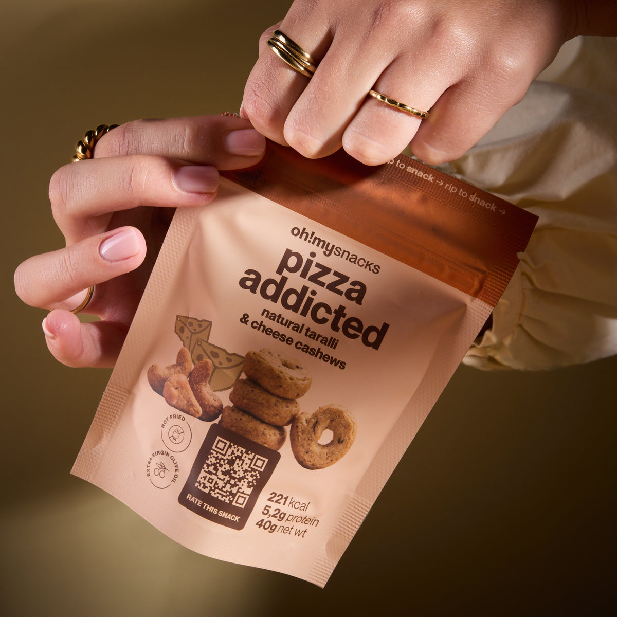 A hand holding a Salty Fusion Pizza Addicted packet