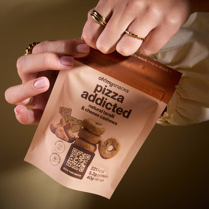 A hand holding a Salty Fusion Pizza Addicted packet