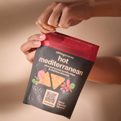 Hands opening a Spicy Fusion Hot Mediterranean packet